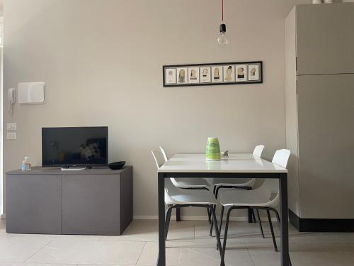 布雷西亚Ca'Sazen Bilo 20的一间带桌椅和电视的用餐室