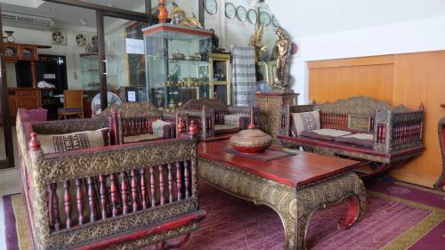 Kaeng Khloโรงแรมไทยงามพาเลซ (Thai Ngam Palace Hotel)的一间配有沙发的房间和商店里的一张桌子