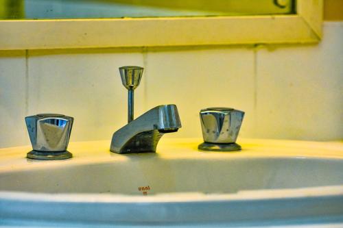 内罗毕Andes by 41 Haven的浴室水槽,配有2个杯子和水龙头