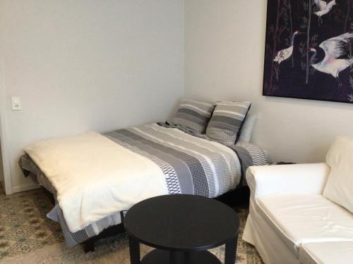 普罗丰德维耶Black and white的客房设有两张床、一张桌子和一张沙发。