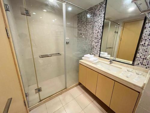 中山中山希曼轻奢酒店公寓的带淋浴、盥洗盆和镜子的浴室