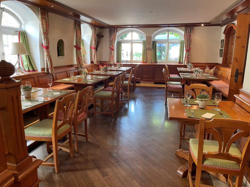 阿本斯贝格Hotel Jungbräu的餐厅设有木桌、椅子和窗户。