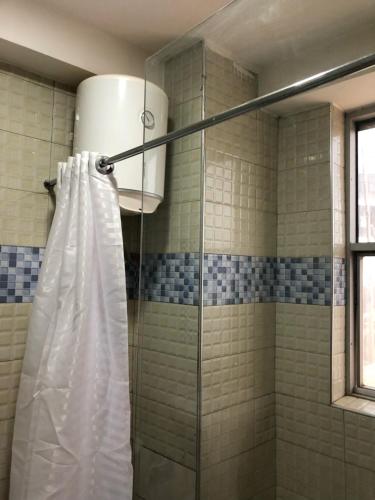 坎帕拉Royal Hotel Apartments的浴室内配有白色淋浴帘。