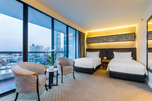 曼谷察殿曼谷沙屯酒店式公寓的酒店客房带两张床和一张桌子以及椅子。