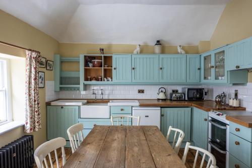 都柏林Merrion Mews的厨房配有蓝色橱柜和木桌
