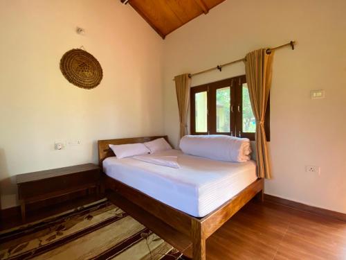 BhurkīāBardia Eco Friendly Homestay的一间小卧室,配有一张带窗户的床