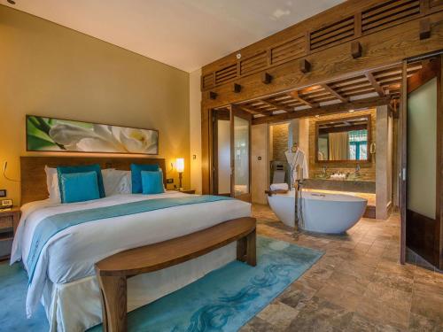迪拜索菲特迪拜棕榈公寓酒店的一间卧室设有一张大床和一个浴缸