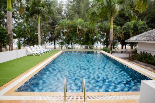 Ban Pak NamLaemsing Natural Beach Resort的一个带椅子的游泳池,棕榈树