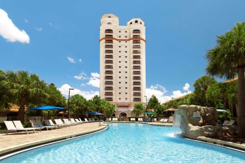 奥兰多DoubleTree by Hilton Hotel Orlando at SeaWorld的大楼前设有游泳池的酒店