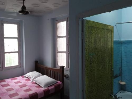 加尔各答Centerpoint Guest House的一间卧室配有一张床、淋浴和浴缸