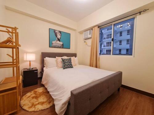 马尼拉Prisma Residences - Celeste的一间卧室设有一张大床和一个窗户。
