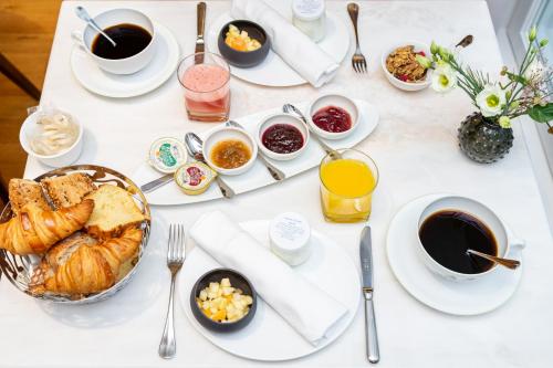 枫丹白露Hôtel de Cavoye的一张带早餐食品和咖啡的白色桌子
