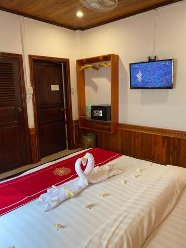 琅勃拉邦Golden Lotus Boutique Hotel的一间卧室配有一张带天鹅的床