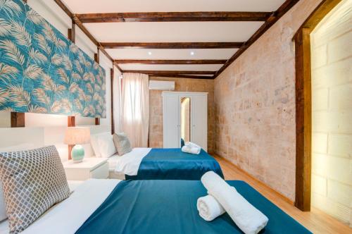 瓦莱塔Valletta Waterfront Villa with Pool and Jacuzzi的一间带两张床和一张沙发的卧室