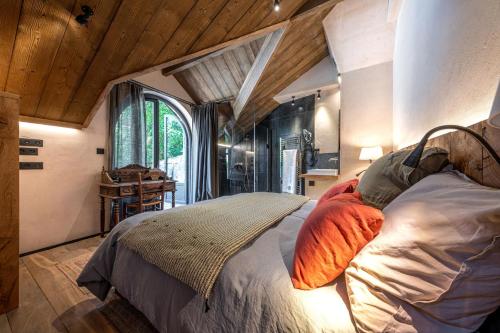 圣马洛La Grange aux Hirondelles - Saint-Malo - St Servan的一间带一张床的卧室,位于带木制天花板的房间内