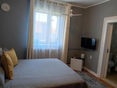 蒂米什瓦拉Crystal Room的一间卧室配有一张带窗户的床和一台电视