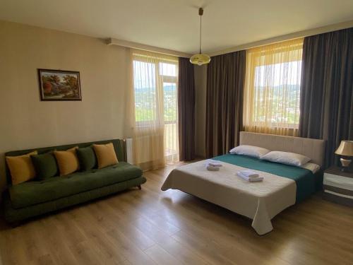 SuramiHotel Legiandro Surami的客厅配有床和沙发