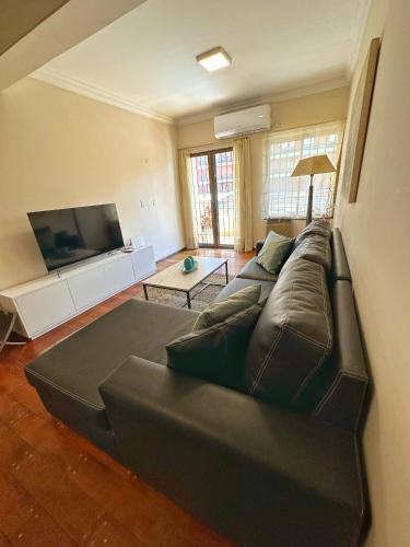 圣米格尔·德·图库玛Paramont Tucuman的客厅配有真皮沙发和平面电视