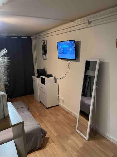 昂吉安班斯Studio Lac d'Enghien的客厅的墙上配有平面电视。