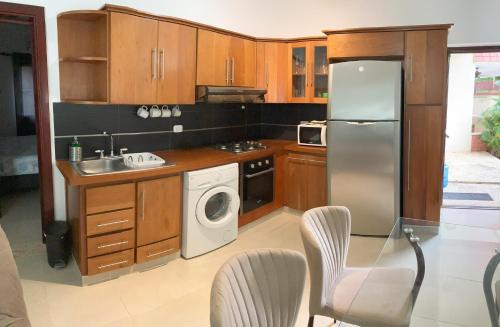 喀巴里特OKAINA 2的厨房配有木制橱柜和不锈钢冰箱。