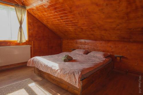 PoeniCabana Amis的木制客房内的一间卧室,配有一张床
