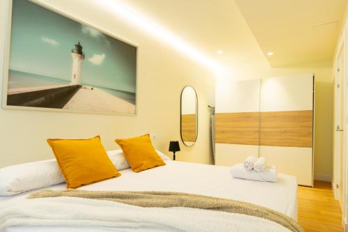 毕尔巴鄂BILBAO NORTH SHORE APARTMENTS 6的一间卧室配有一张带黄色枕头的床和一座灯塔。
