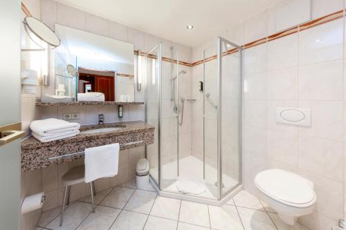 巴特克罗青根Parkhotel an der Therme的带淋浴、卫生间和盥洗盆的浴室