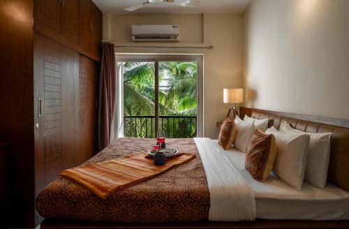 巴加Goa Chillout Apartment - 1BHK, Baga的一间卧室配有一张床,上面有托盘