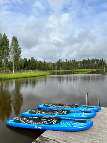 Atpūtas vieta Jaunkārkliņi的一群坐在湖上的蓝色独木舟