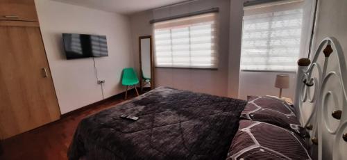 拉巴斯Acogedor apartamento cerca del teleférico amarillo的一间卧室配有一张床和一台平面电视