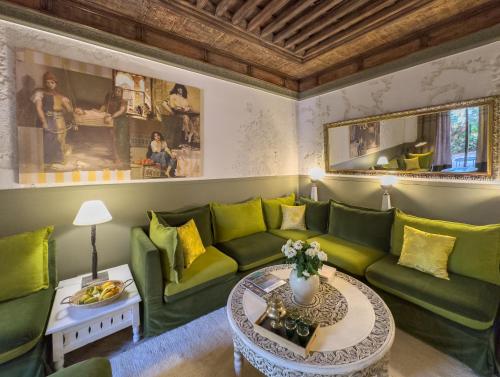 马拉喀什Maison Maria Palmeraie的客厅配有绿色沙发和桌子