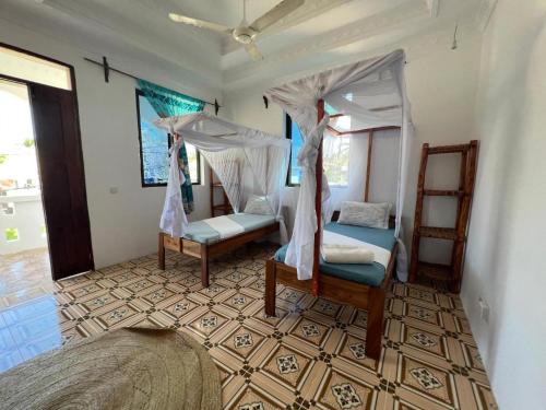 帕杰Mauwa House的一间卧室设有两张床和天篷