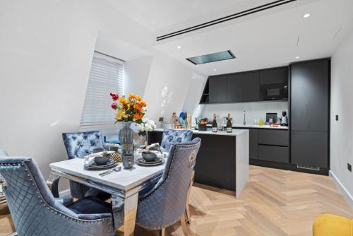 伦敦Marble Arch Penthouse 1 Bed的厨房以及带桌椅的用餐室。