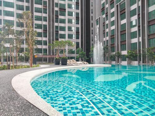 吉隆坡Cubic Botanical Suites Bangsar South by HomeBrickz的一座大楼前的游泳池,带喷泉
