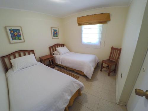 皮卡Cabañas La Huayca - Caja Los Andes的一间卧室设有两张床和窗户。