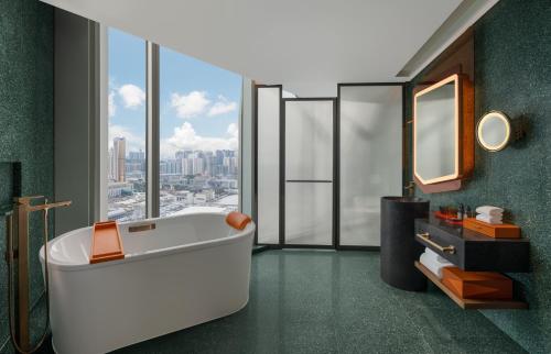澳门W Macau - Studio City的带浴缸的浴室和大窗户