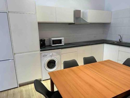 穆尔西亚Apartamento Murcia San José B的厨房配有桌子和洗衣机。