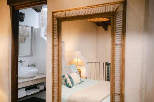 危地马拉安地瓜Boutique Villa in Antigua的浴室设有镜子、床和水槽