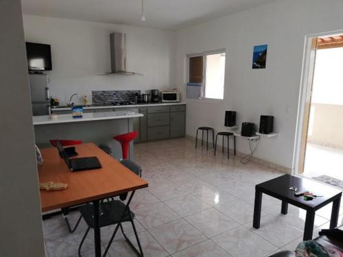 明德卢Casa Yô的厨房以及带桌椅的起居室。