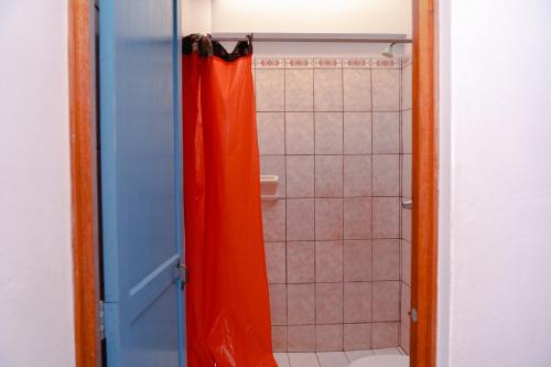 利马Yaki Hostel的浴室配有带橙色淋浴帘的淋浴
