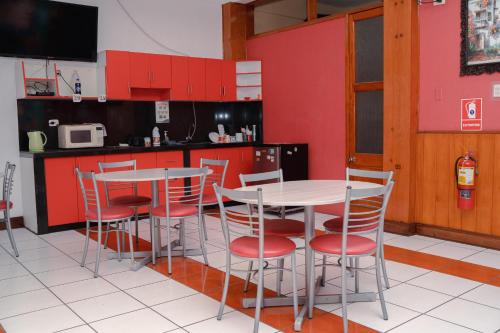 利马Yaki Hostel的厨房配有红色橱柜和桌椅