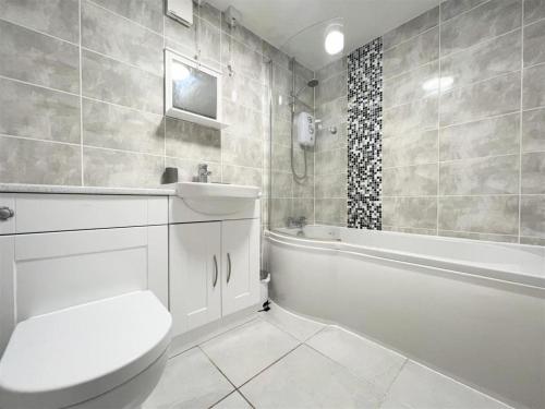 纽基Newquay Fistral Beach View的浴室配有卫生间、浴缸和水槽。