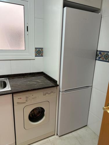 滨海阿雷尼斯Apartament Port的厨房配有冰箱和洗衣机。