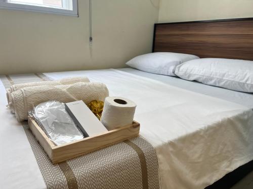 马尼拉Condotel Room to Stay Lodging的一张带带卫生纸托盘的床铺