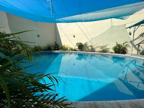 马尼拉Condotel Room to Stay Lodging的蓝色的大游泳池,带蓝伞