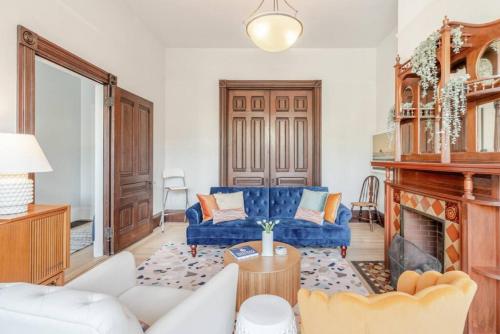 旧金山Charming Victorian Oasis with an Elegant and Spacious Haven的客厅设有蓝色的沙发和壁炉