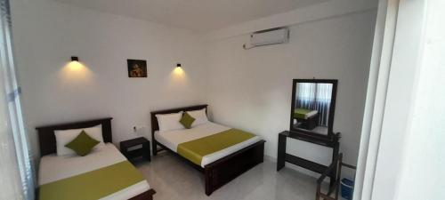 阿努拉德普勒Lake Edge Resort的一间小卧室,配有两张床和镜子