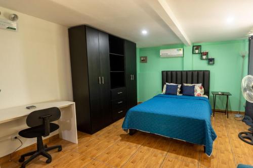 奎波斯城CASA KENJY的一间卧室配有蓝色的床、一张桌子和一把椅子