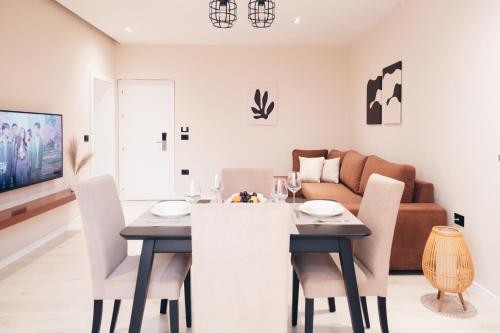 地拉那Mono Boutique Apartments的用餐室以及带桌椅的起居室。