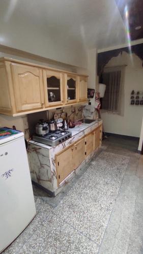 马拉喀什Résidence gharnata D5的厨房配有木制橱柜和炉灶烤箱。